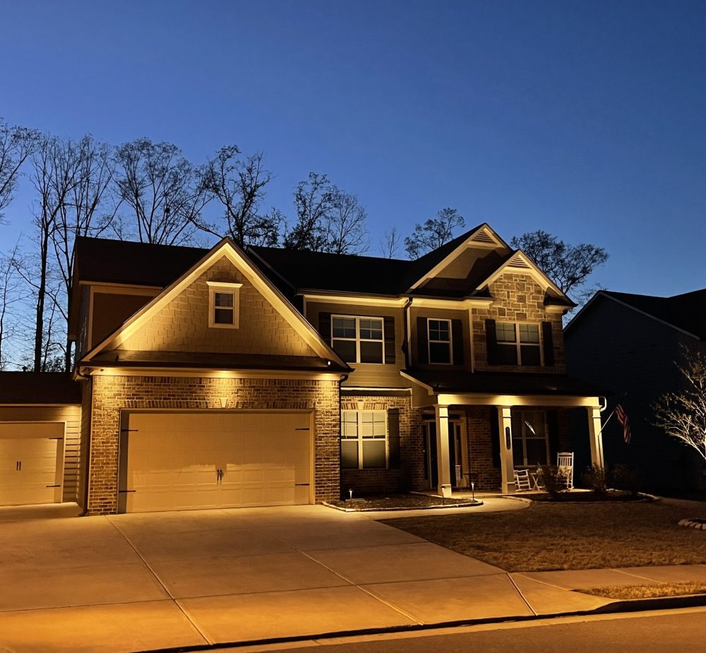 Exterior view of a home with landscape lighting highlighting architectural features. Atlanta, GA